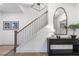 Modern staircase with dark wood railings and a black console table at 130 Chiswick Cir, Alpharetta, GA 30009