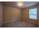 Simple bedroom with carpet, window, and neutral walls at 85 Providence Pkwy, Covington, GA 30014