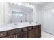 Double vanity bathroom with dark brown cabinets and a large mirror at 6019 Wheeler Ridge Rd, Auburn, GA 30011