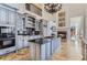 Modern kitchen with gray cabinets, a large island, and stainless steel appliances at 9620 Cedar Grove Rd, Chattahoochee Hills, GA 30213