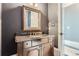 Powder room with dark vanity, granite countertop and ornate mirror at 9620 Cedar Grove Rd, Chattahoochee Hills, GA 30213
