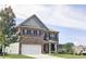 Two-story brick home with a three-car garage, front yard, and mature tree at 222 Gallant Fox Way, Acworth, GA 30102