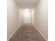 Long hallway with neutral carpeting and double doors at the end at 280 Green Commons Dr, Covington, GA 30016
