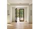 Bright and airy entryway with herringbone wood floors and French doors at 8350 Farmette Bnd, Chattahoochee Hills, GA 30268