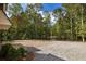 Gravel driveway with ample parking space, leading to a charming home nestled in a wooded setting at 8350 Farmette Bnd, Chattahoochee Hills, GA 30268