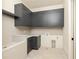 Laundry room with dark gray cabinets and tile flooring at 8350 Farmette Bnd, Chattahoochee Hills, GA 30268