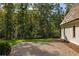 Landscaped yard with mature trees and gravel driveway at 8350 Farmette Bnd, Chattahoochee Hills, GA 30268