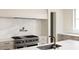 Luxury kitchen boasts a professional range, marble backsplash, and sleek cabinetry at 8350 Farmette Bnd, Chattahoochee Hills, GA 30268