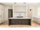 Modern kitchen with large island, marble backsplash and herringbone floors at 8350 Farmette Bnd, Chattahoochee Hills, GA 30268