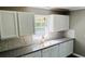 Updated kitchen boasts white cabinets, granite countertops, and a mosaic tile backsplash at 130 Taunton Rd, Covington, GA 30014