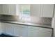 Modern kitchen features granite counters, white shaker cabinets, mosaic tile backsplash, and stainless steel sink at 130 Taunton Rd, Covington, GA 30014