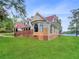 Lakefront home with red roof, brick accents, and a spacious lawn at 300 Jonesboro Rd, Mcdonough, GA 30253