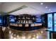 Modern bar with a curved counter, pendant lights, and screens at 45 Ivan Allen Jr Nw Blvd # 2306, Atlanta, GA 30308