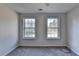 Well-lit bedroom featuring carpet floors and two large windows at 3390 Wake Robin Way, Cumming, GA 30040