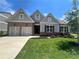 Two-story home with gray siding, brick accents, and a two-car garage at 312 Willow Cv, Canton, GA 30114