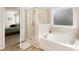 Bathroom with soaking tub, walk-in shower, and view into bedroom at 4121 Dean Grove Way, Loganville, GA 30052