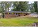 Brick ranch house with yellow shutters, large yard, and carport at 3689 Laurie Woods Ln, Decatur, GA 30034