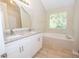 Bathroom with granite countertops, double sinks, and a garden tub at 10074 Tara Glynn Dr, Hampton, GA 30228