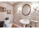 Elegant powder room with pedestal sink, toilet, and decorative wallpaper at 8561 Lake Forrest Dr, Douglasville, GA 30134