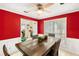 Dining room with red walls, wooden table, and ceiling fan at 721 Simon Park Cir, Lawrenceville, GA 30045