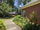 Brick home with landscaped backyard, walkway, and lush greenery at 595 Huiet Dr, Mcdonough, GA 30252