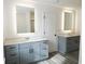 Double vanity bathroom with gray cabinets, quartz countertops, and illuminated mirrors at 3301 Pepperpike Ct, Loganville, GA 30052