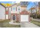Brick townhouse with attached garage and well-maintained landscaping at 5100 Windsor Forrest Ln, Atlanta, GA 30349