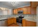 Kitchen with wood cabinets, stainless steel appliances, and tile backsplash at 705 Chase Ln, Mcdonough, GA 30253