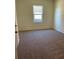 Spacious bedroom with carpet flooring and a window overlooking the backyard at 7520 Saffron Ave, Covington, GA 30014