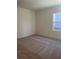 Well-lit bedroom with neutral carpeting and a window offering natural light at 7520 Saffron Ave, Covington, GA 30014