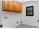 Laundry room with wood cabinets and patterned tile floor at 4978 Thornwood Nw Cv, Acworth, GA 30102