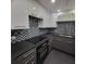 Modern kitchen with dark gray and white cabinets, glass tile backsplash and black countertops at 375 Ralph Mcgill Blvd # 505, Atlanta, GA 30312