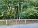 View of a wooded backyard from a deck with wooden railings at 835 Amelia Grove Ln, Lawrenceville, GA 30045