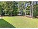 Large, grassy backyard with a wooden fence and mature trees at 12227 Cypress Ln, Fayetteville, GA 30215