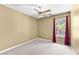 Beige bedroom with carpet, window, and ceiling fan at 12227 Cypress Ln, Fayetteville, GA 30215