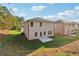 Two-story house with light beige siding and backyard patio at 7739 Richmond Trl, Fairburn, GA 30213