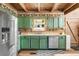 Rustic kitchen with green cabinets, stainless steel appliances and hardwood floors at 7790 Atlanta Newnan Rd, Chattahoochee Hills, GA 30268