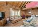 Cozy living room with vaulted ceiling and stone fireplace at 7790 Atlanta Newnan Rd, Chattahoochee Hills, GA 30268