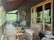 Front porch with rocking chairs and wooded view at 7790 Atlanta Newnan Rd, Chattahoochee Hills, GA 30268