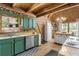 Rustic kitchen with green cabinets, stainless steel appliances and hardwood floors at 7790 Atlanta Newnan Rd, Chattahoochee Hills, GA 30268