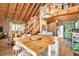 Rustic kitchen with wood floors and green cabinets; view of staircase to loft at 7790 Atlanta Newnan Rd, Chattahoochee Hills, GA 30268
