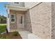 Brick front entrance with a glass door and small porch at 2011 Wyndham Pl, Conyers, GA 30013