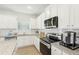 Modern kitchen with white cabinets, granite countertops and stainless steel appliances at 2010 Wyndham Pl, Conyers, GA 30013