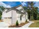 White brick house with three car garage and side yard at 2004 Fontainbleau Dr, Conyers, GA 30094