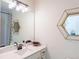 Bathroom with single vanity, hexagon mirror, and shower/tub combo at 2004 Fontainbleau Dr, Conyers, GA 30094