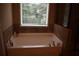 Relax in this garden tub, complete with a large window and tile surround at 3853 Locksley Trl, Douglasville, GA 30135