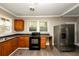 Bright kitchen featuring wood cabinets, stainless steel appliances, and vinyl flooring at 15 Johnson Nw Rd, Atlanta, GA 30318