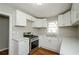 Renovated kitchen featuring white cabinets, quartz countertops, and stainless steel appliances at 123 Arnold Pl, Jonesboro, GA 30236