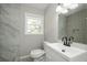 Updated bathroom with gray tile, white vanity, and black fixtures at 123 Arnold Pl, Jonesboro, GA 30236