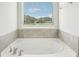 Garden tub with large window and view of backyard at 3024 Viewpark Cir, Conyers, GA 30013